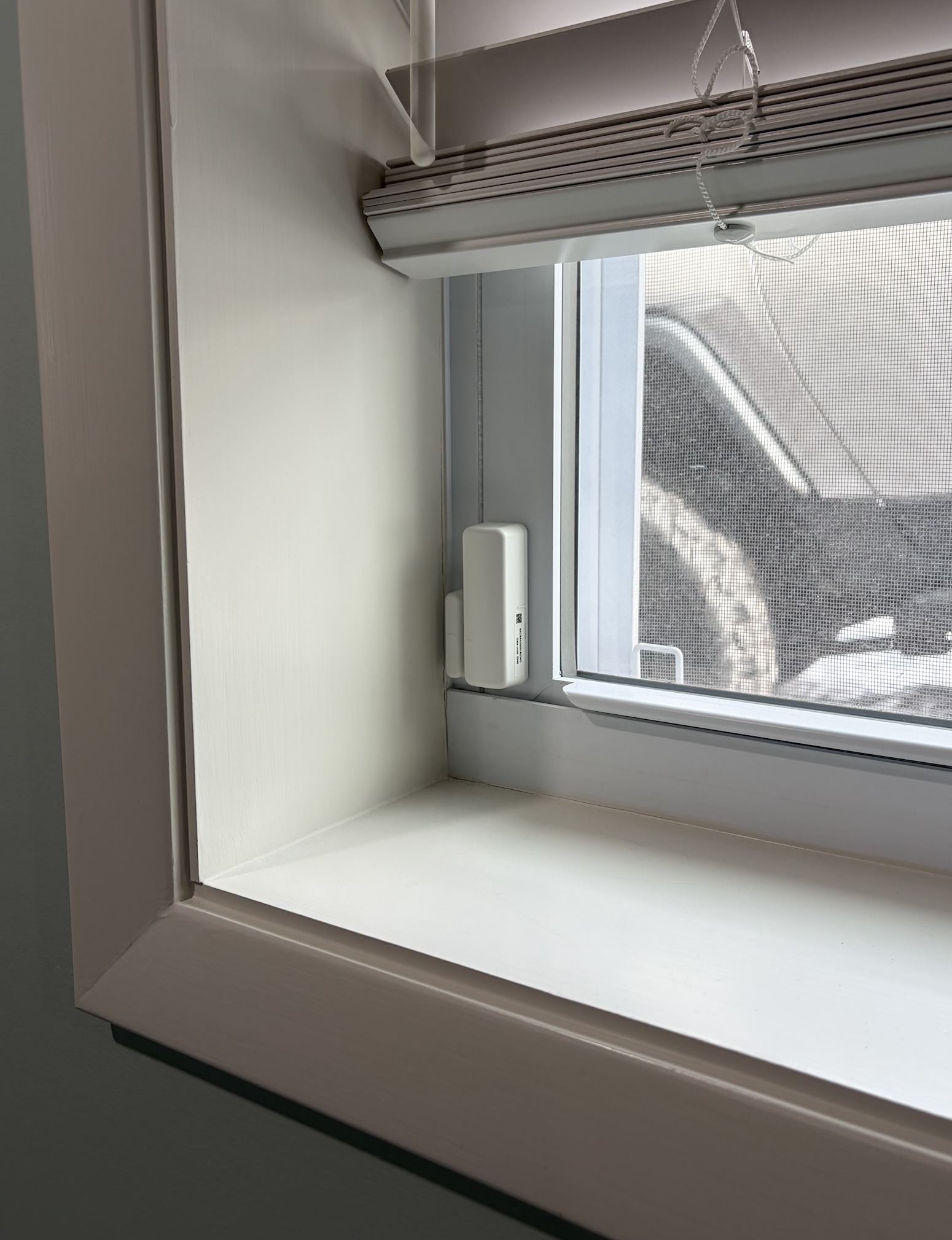 Wireless Pro Series contact sensor mounted on a window frame to monitor window openings for home security.